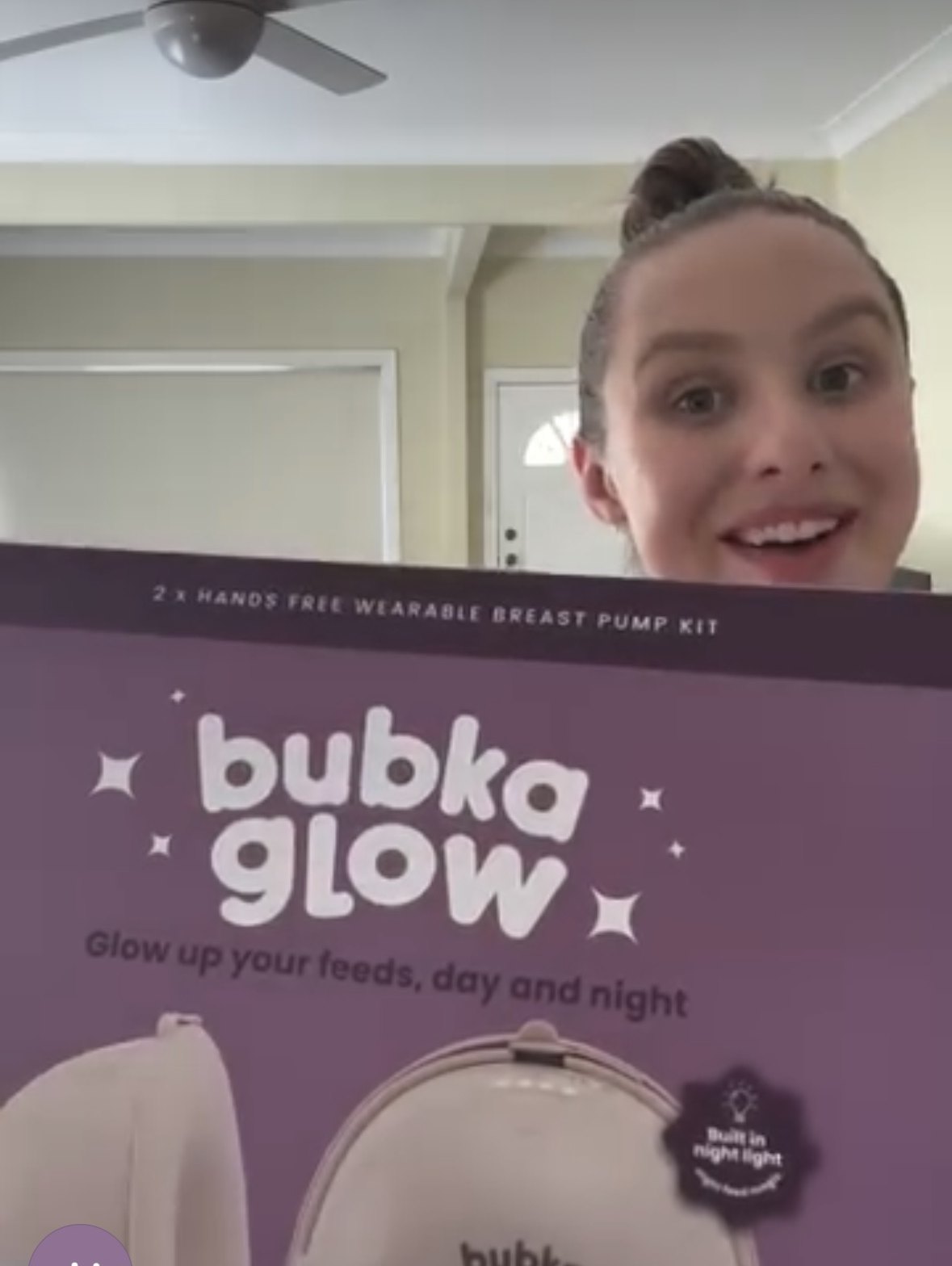 Ash holding up a Bubka Glow wearable breast pump box
