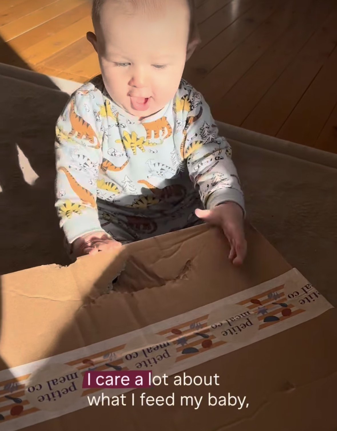 Baby opening a Petite Meal Co delivery box